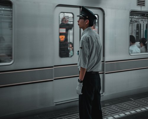 A commuter standing on a train, maintaining a relaxed upright posture